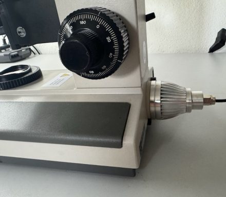Ein älteres Gerät mit einem großen Drehknopf und einer Metallspitze auf einem Tisch.
