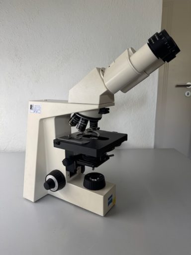 Mikroskop auf einem Tisch, bereit zur Verwendung in einem Labor.